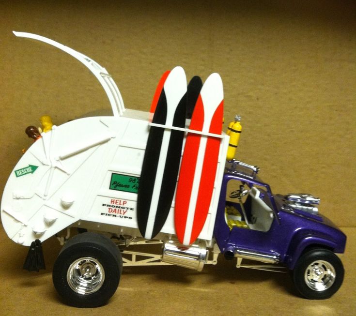 a toy truck with surfboards attached to it's back end and the door open