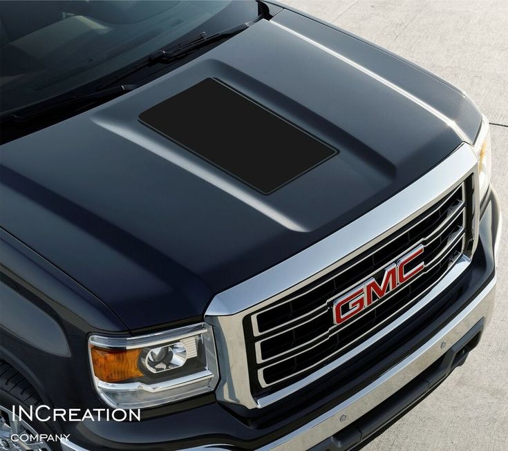 the front grille and hood of a black gmc truck with an emblem on it