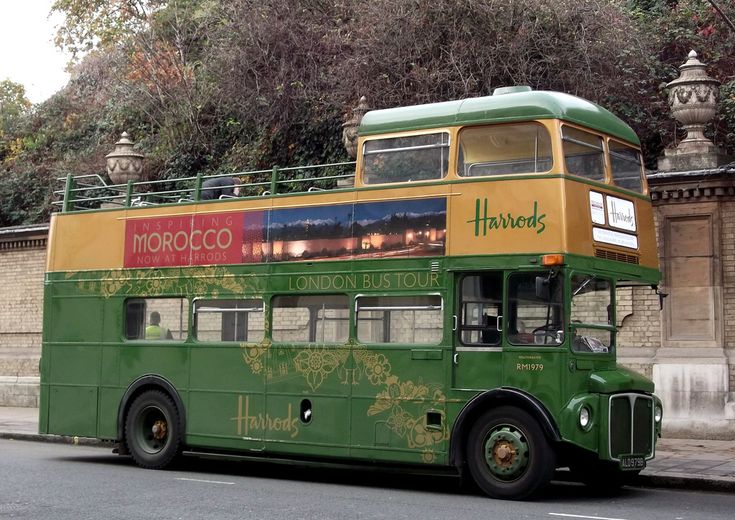 a green and yellow double decker bus driving down the street