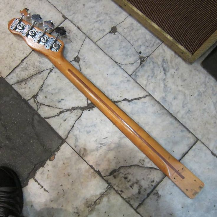 an electric guitar laying on the ground next to a person's legs and foot