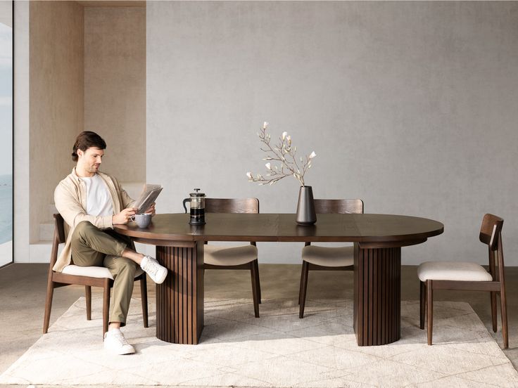 a woman sitting at a table reading a magazine