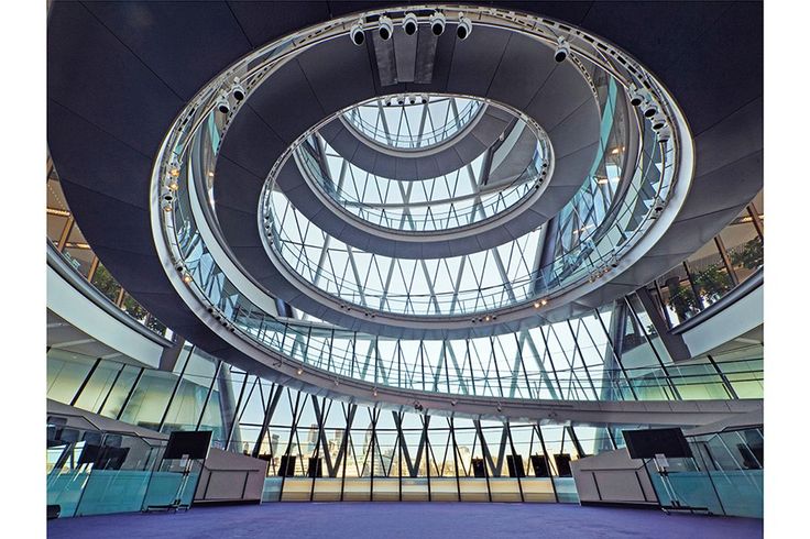 the inside of a building with many circular windows and blue carpeted flooring in front of it