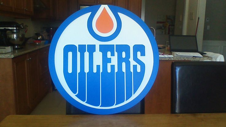 the edmonton oilers logo is shown in blue and white with an orange flame on it