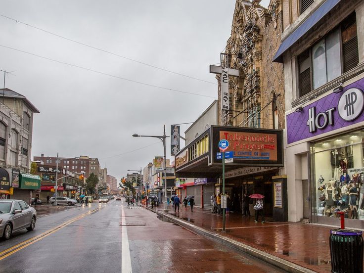 a wet city street with cars parked on the side