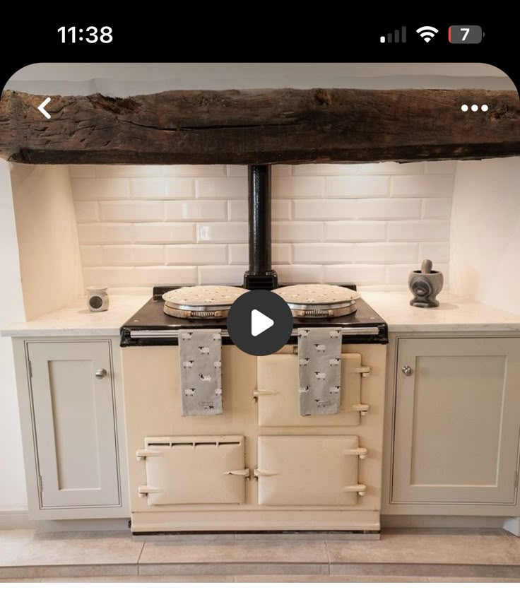 an old fashioned stove in a kitchen with white cabinets