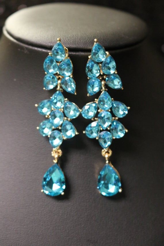 Aqua Blue Earrings Posts Something Blue drop earrings wedding bridal Teal Blue Chandelier Drop Teardrop Turquoise Blue Earrings Prom PageantHUGE aqua blue earrings are made with small teardrop crystals attached to gold settings. The teardrop blue jewels below are 10X14 mm and the teardrop crystals above are 8mm X 10mm. The earrings are a tad bigger than 2.6". They shine with a timeless beauty and would go with a wedding outfit, prom, pageant, bridesmaid or on your special day. I have also shown Yellow Topaz Ring, Drop Earrings Wedding, Earrings Prom, Blue Chandelier, Blue Drop Earrings, Pear Earrings, Teal Earrings, Wedding Earrings Drop, Prom Earrings