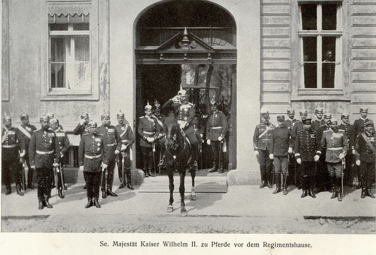 an old black and white photo of men in uniforms on horses standing outside a building