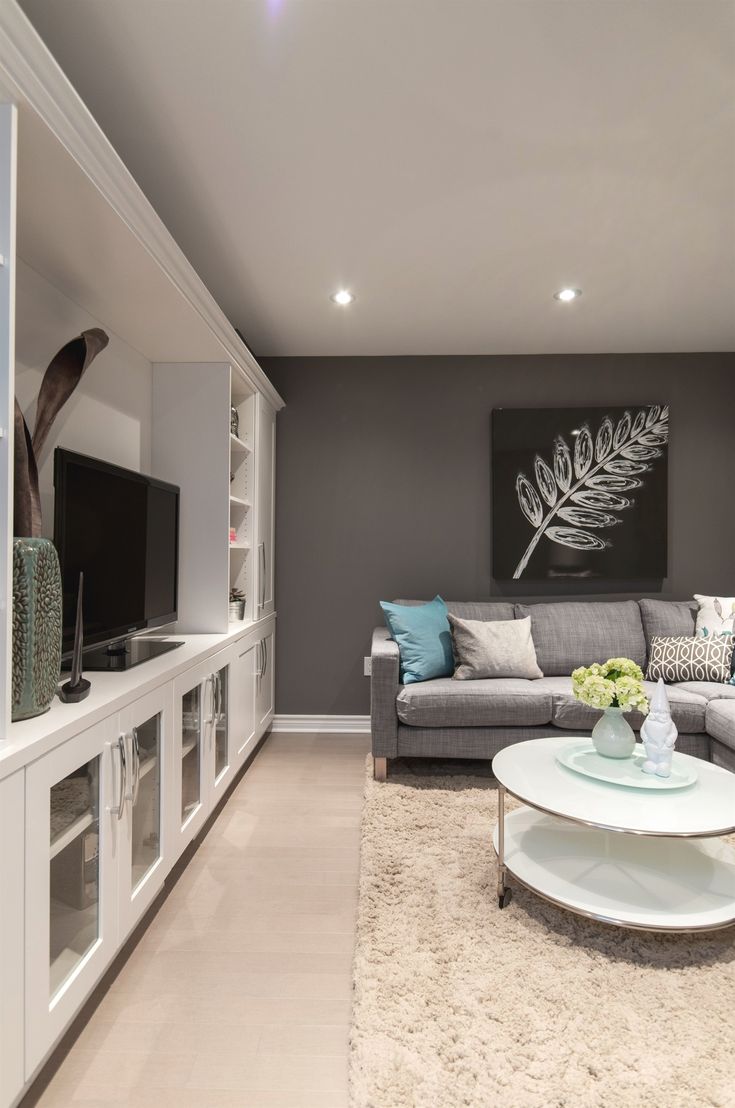 a living room filled with furniture and a flat screen tv on top of a wall