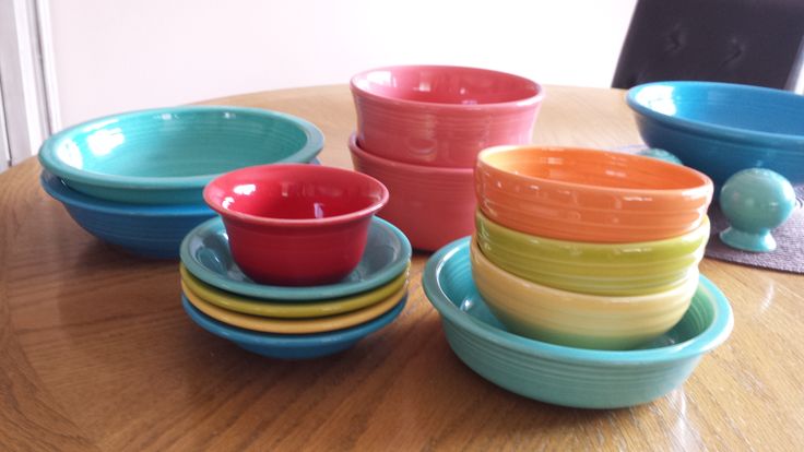 there are many bowls on the table and one bowl is red, yellow, green, blue