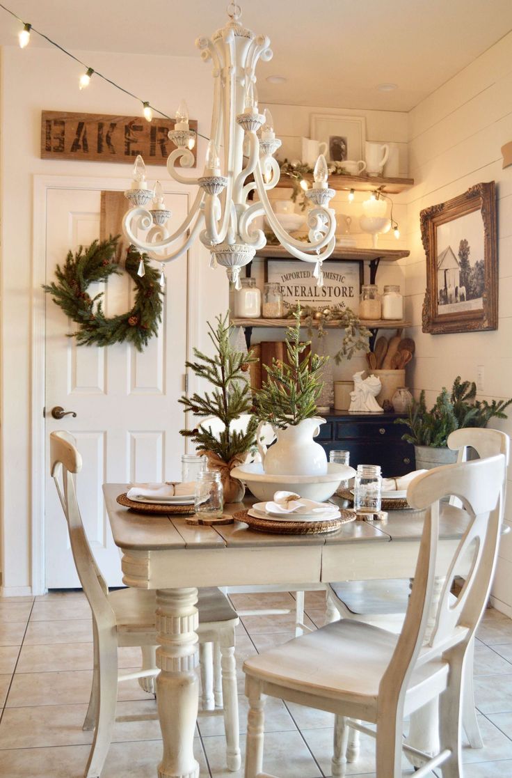 a white dining room table with chairs and a chandelier