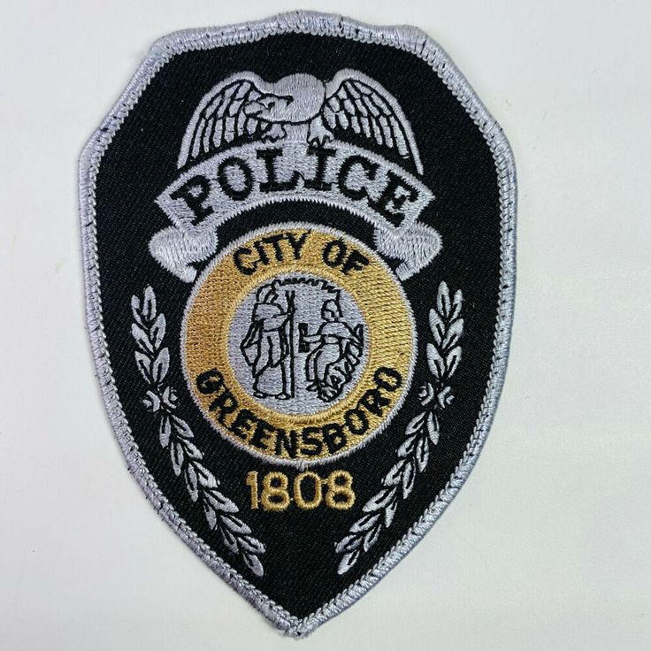 the police badge is on top of a white wall and it says, city of greensburg 1088