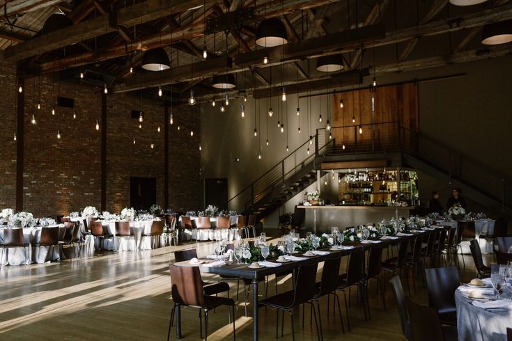 an empty dining hall with tables and chairs set up for formal function or wedding reception