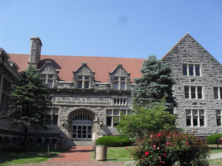 an old stone building with trees and bushes around it