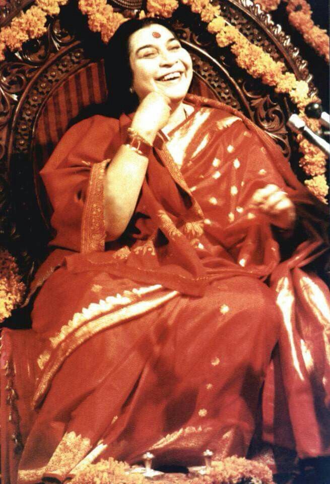 a woman sitting on top of a metal chair with flowers around her neck and eyes closed