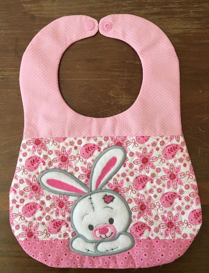 a pink bib with a cartoon bunny on it