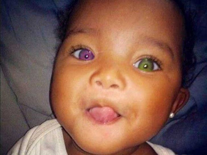 a close up of a baby with green eyes