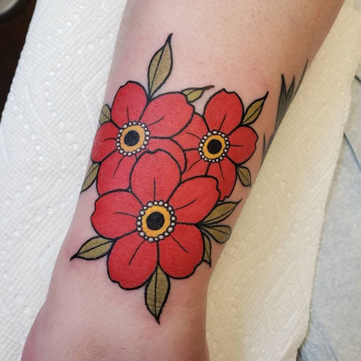 a red flower tattoo on the left arm