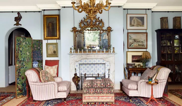 a living room filled with furniture and a fire place under a chandelier over a fireplace