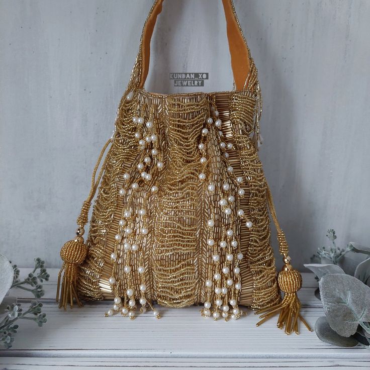 -GOLD PEARL BEADED POTLI HANDBAG-  Regal designer clutch with heavy hand embroidery is sure to turn heads! Elegantly embellished with pearl tassels and BEADS in beautiful warm tones on a matte gold base. Fully stitched with hand embellishments all over. Indo-western potli handbag comes with stitched top handle with bead work and soft velvet internal lining.  PERFECT clutch sized to fit most  phones and accessories in style! Makes a great gift too! Our beautiful Indo-western design done in our mo Evening Festival Potli Bag With Tassels, Evening Potli Bag With Tassels For Festivals, Festive Evening Bags With Tassels, Gold Potli Bag With Tassels For Party, Festival Potli Bag With Latkans For Reception, Traditional Bags With Latkans For Reception, Festive Gold Potli Bag With Tassels, Festival Reception Potli Bag With Latkans, Festive Potli Bag With Latkans For Receptions