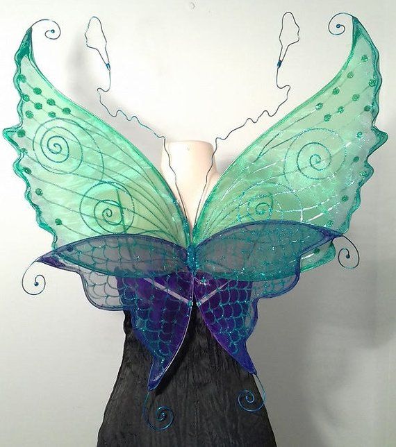 a green and blue butterfly wings on a mannequin headdress with swirls