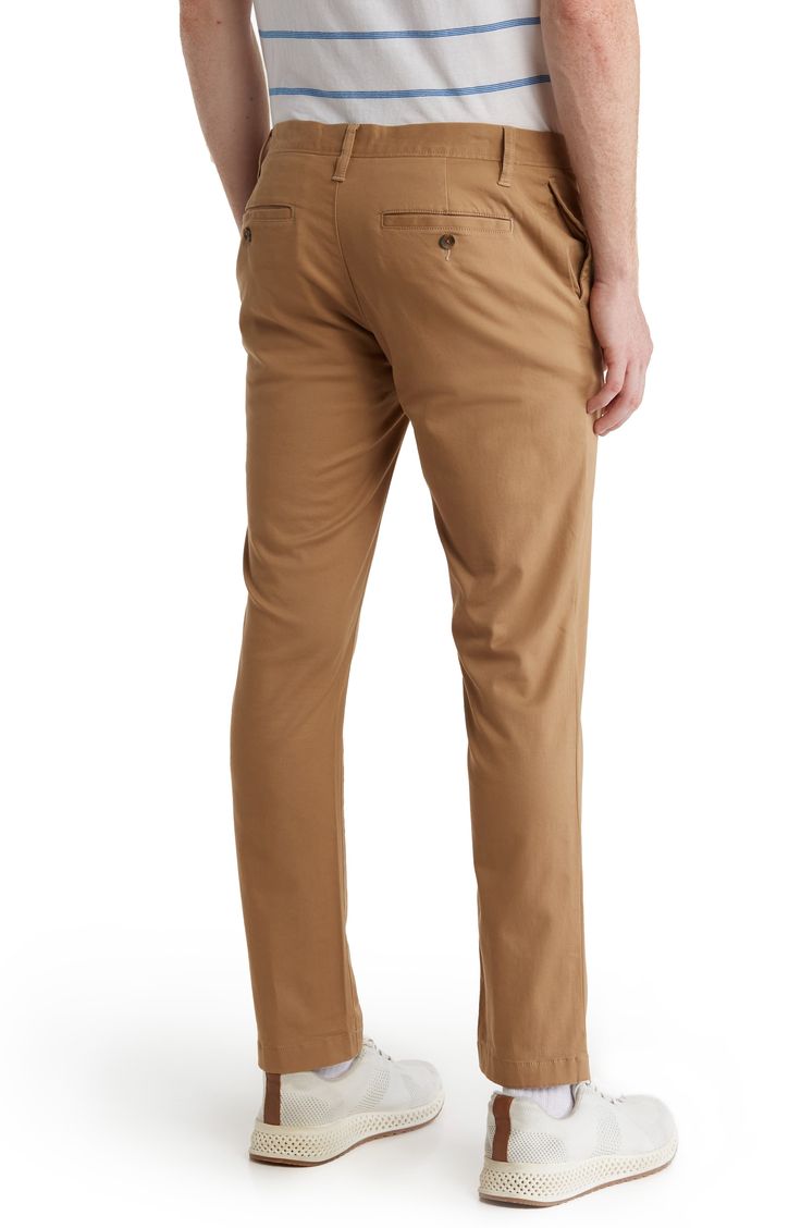 A solid hue makes these chino pants a versatile, everyday classic staple for your closet. 9" rise, 32" inseam (size 32x32) Trim fit Zip fly with button closure 2 front slash pockets; 2 back button welt pockets 97% cotton, 3% spandex Machine wash, tumble dry Imported Slim Fit Straight Leg Solid Chinos, Solid Color Slim Fit Straight Leg Chinos, Slim Fit Straight Leg Chinos, Solid Straight Cotton Bottoms, Solid Cotton Straight Bottoms, Fitted Straight Chinos For Fall, Everyday Chinos With Tapered Leg And Straight Fit, Everyday Chinos With Straight Fit And Tapered Leg, Chinos With Pockets And 5-inch Inseam