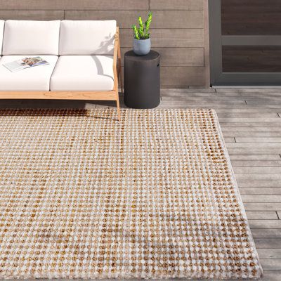 a white couch sitting on top of a wooden floor next to a potted plant