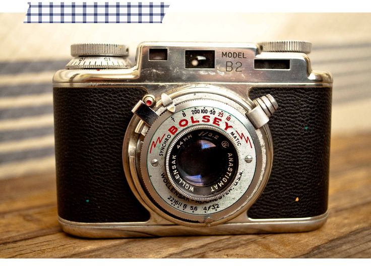 an old camera sitting on top of a wooden table