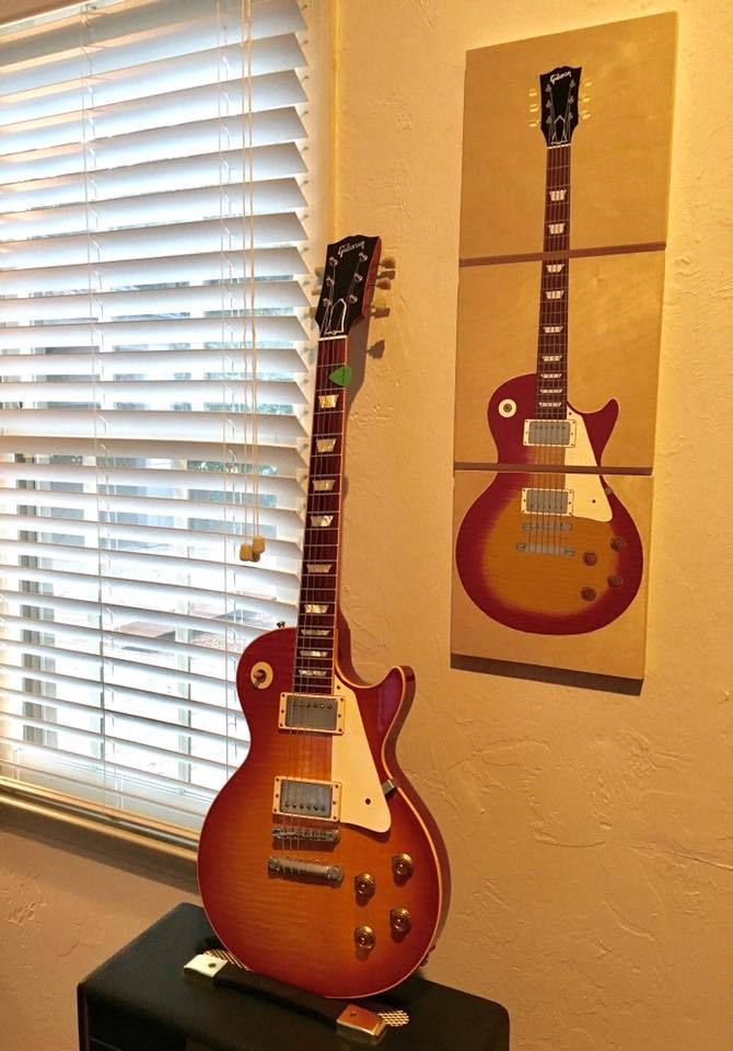 two guitars are on display in front of a window