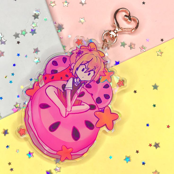 a keychain with a cartoon character sitting on top of a donut and stars