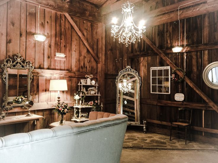 an old fashioned bathroom with wooden walls and exposed ceiling, chandelier above the bathtub