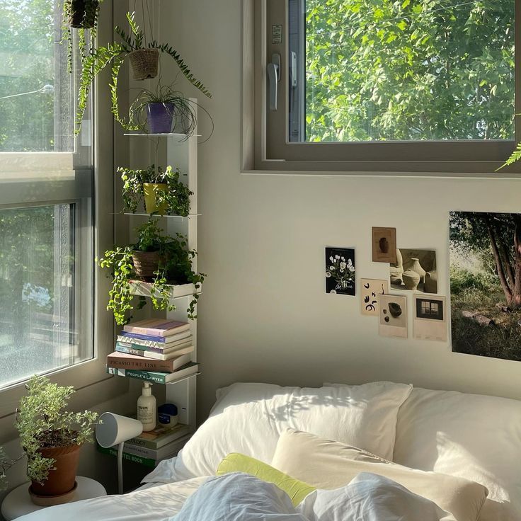 a bedroom with plants and pictures on the wall