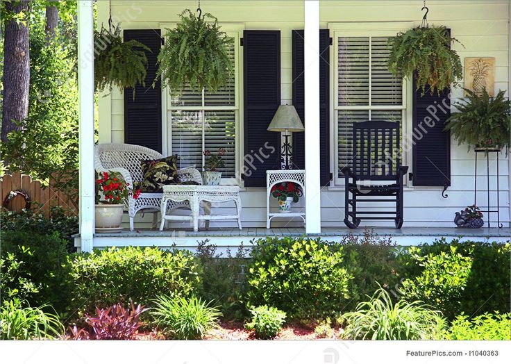 a porch with chairs and potted plants on it