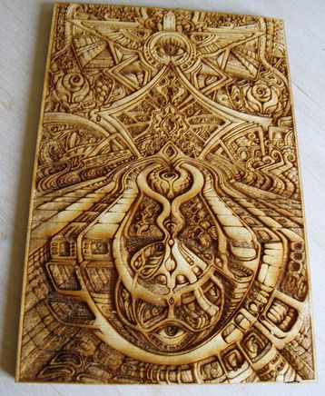 an intricately carved wooden plaque on a white surface with the image of a bird