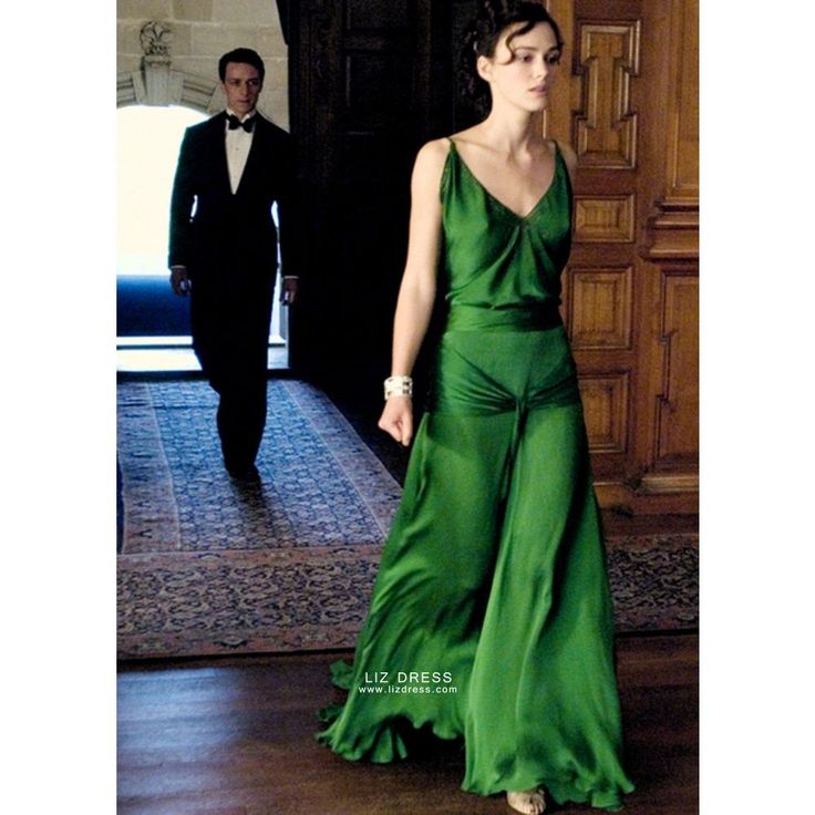 a woman in a green dress and a man in a tuxedo are walking