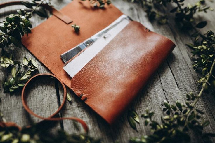 a brown leather notebook with green leaves around it