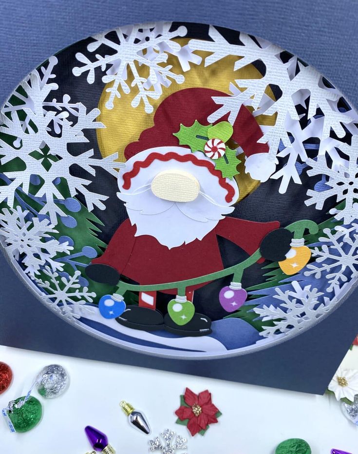 a paper plate with a santa clause on it's face and snowflakes around it