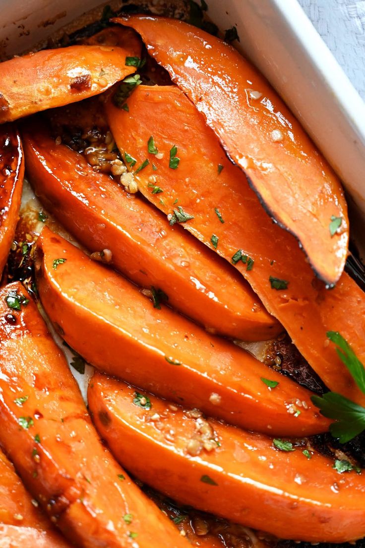 cooked carrots with herbs and seasoning in a white dish