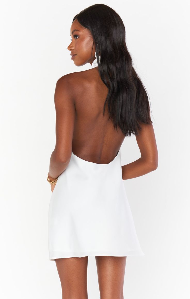 Our best selling halter maxi is now in mini length! This white mini is cut on the bias to give that perfect slip draping we're all looking for. The top softly wraps around your neck for a flattering high neck and leaves a dramatic open back. Beyond chic for a bridal shower and a new go-to for special occasions and events! White Backless Dress For Date Night, White Backless Mini Dress For Date Night, White Spaghetti Strap Backless Dress For Date Night, White Halter Neck Dress For Night Out, Sleek Summer Backless Dress With Tie Back, Chic Backless Slip Dress With Ruched Back, Chic Backless Slip Dress With Back Opening, Halter Neck Backless Dress For Date Night, Chic White Backless Dress For Night Out