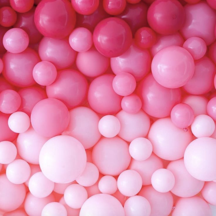 pink and white balloons are arranged in a pattern on the wall, as seen from above