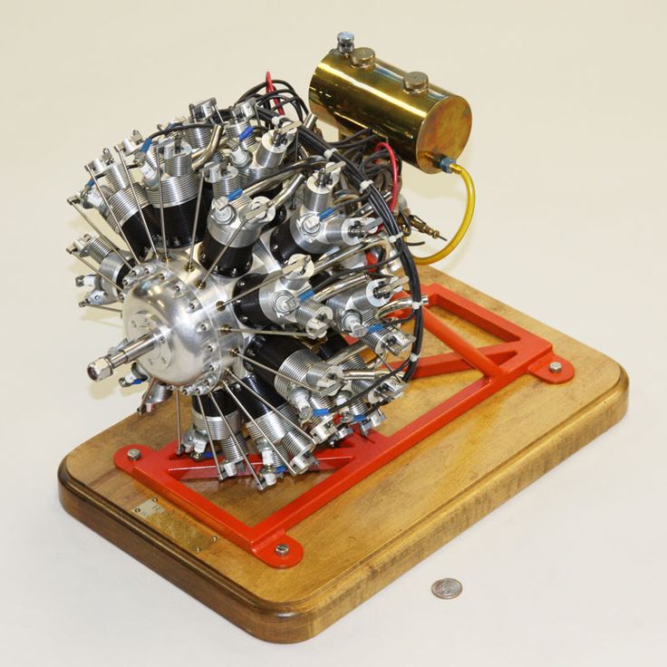 an engine is sitting on top of a piece of wood and has metal parts attached to it