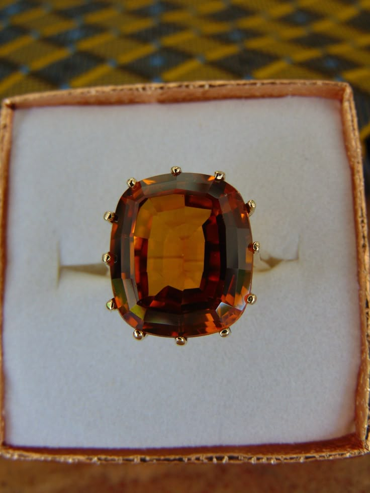 Wow! What a exquisite 10KtYg Lab Created Orange Sapphire.  Size 8 3/4 with the Solitaire stone at approximately 12 Carats. 7.5 g.  Stamped 10KtYg inside.  The fire in this stone is beyond eye catching.  Can be resized or a ring guard added.  Stone is prong set.  I have my jeweler and his gemologist wife look at each estate jewelry that I have.  This preloved ring is coming from a clean nonsmoking home. Luxury Amber Topaz Wedding Ring, Classic Luxury Orange Topaz Ring, Luxury Orange Topaz Wedding Ring, Luxury Classic Orange Topaz Ring, Luxury Vintage Orange Rings, Luxury Amber Topaz Ring For Wedding, Engagement Rings Amber Stone, Luxury Amber Engagement Ring, Luxury Amber Topaz Ring In Classic Style