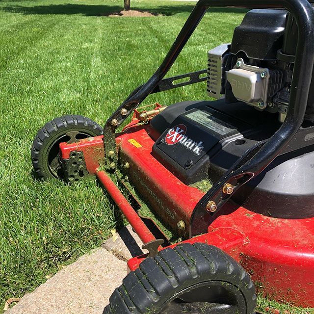 a red lawn mower sitting in the grass