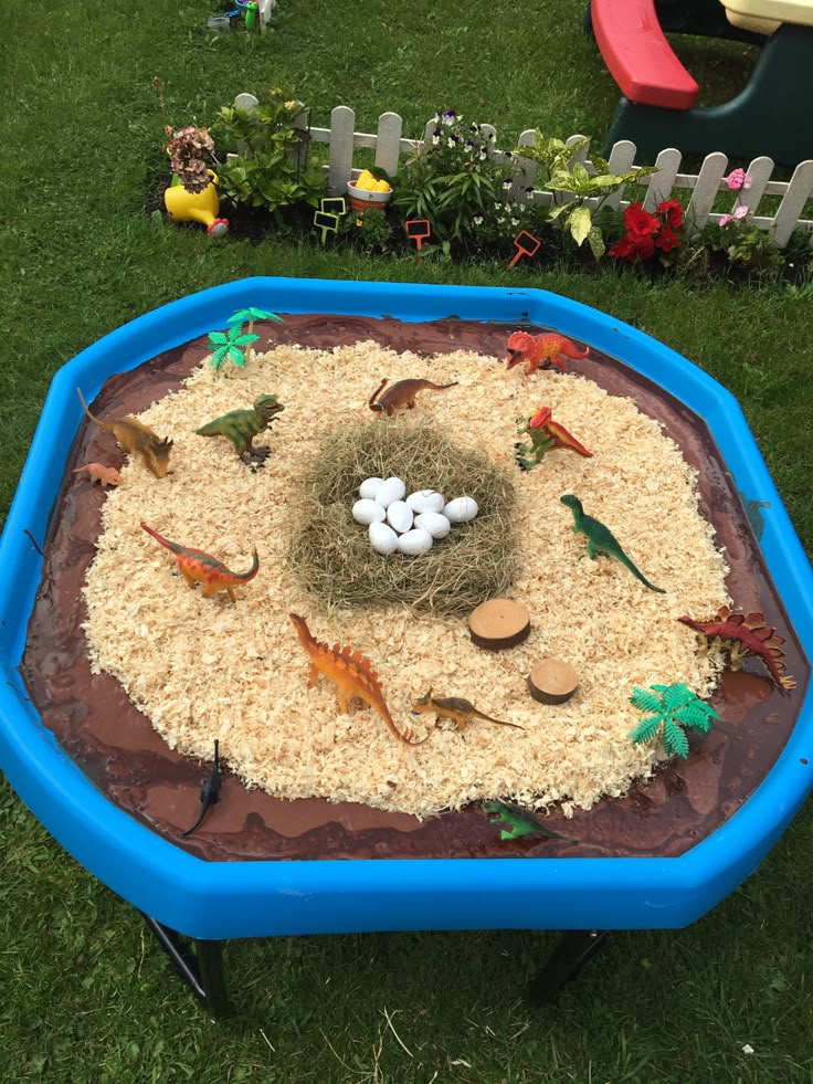 a bird's nest in the middle of a sandbox filled with fake birds