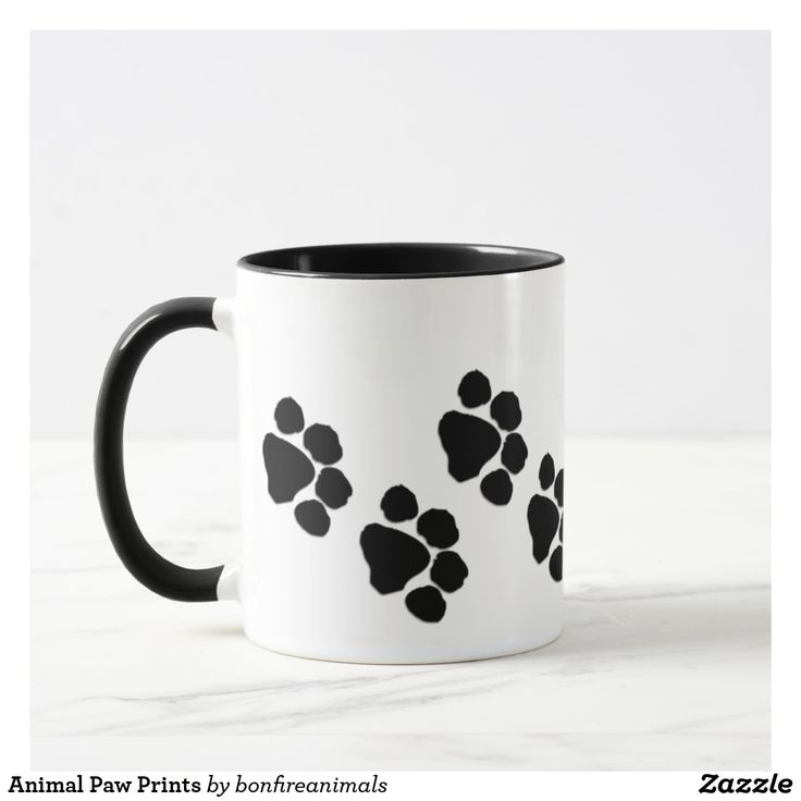 a black and white coffee mug with paw prints