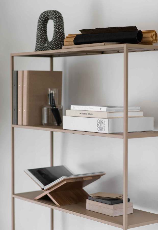 a book shelf with books, notebooks and other items on it in a white room