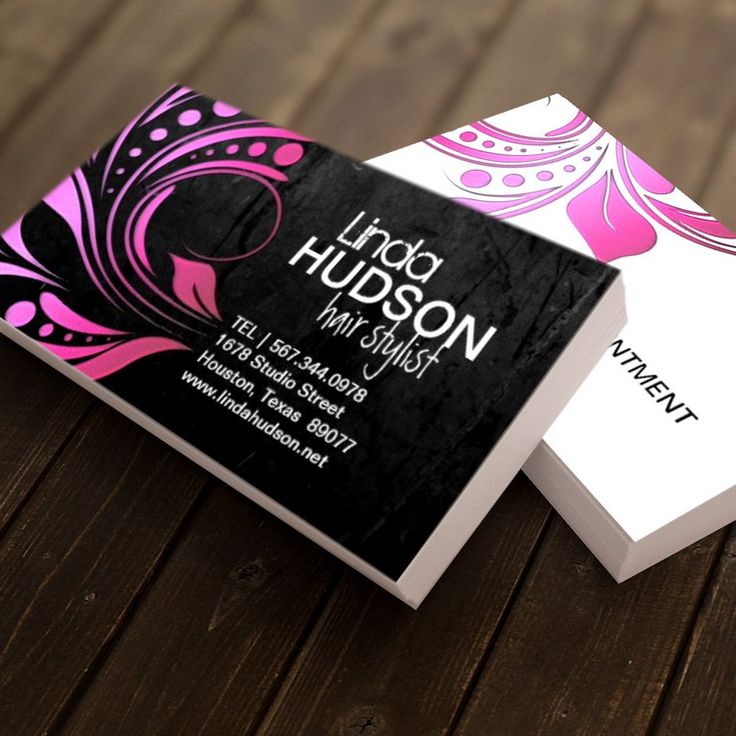 two business cards sitting on top of a wooden table with pink and black designs in the middle