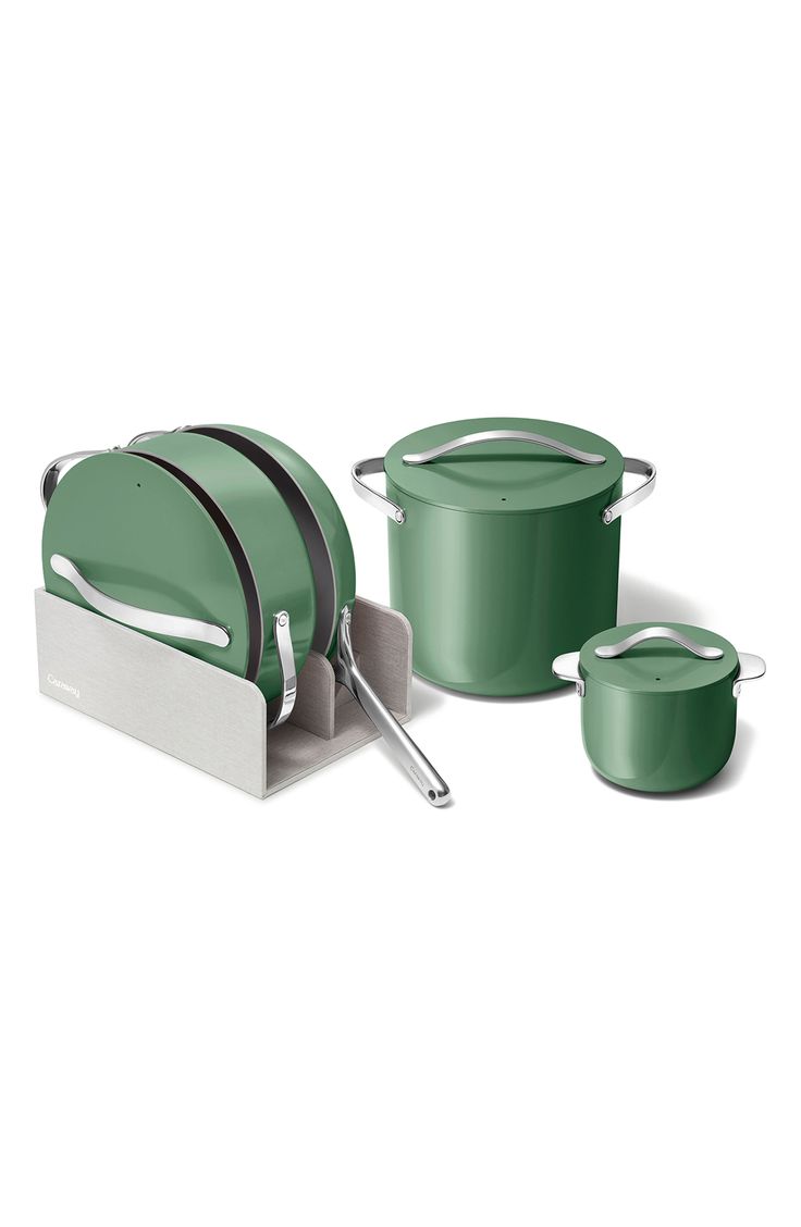 the green pots and pans are set up in front of each other with their lids open