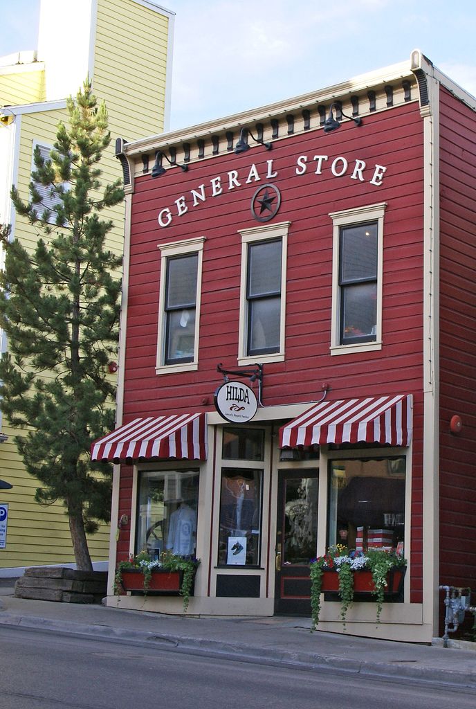 a red building with striped awnings on the side of it's front