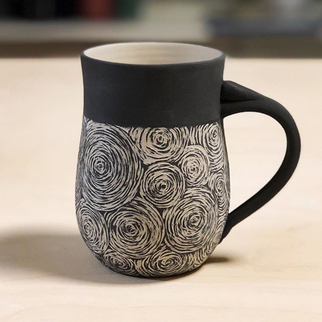 a black and white coffee mug sitting on top of a table