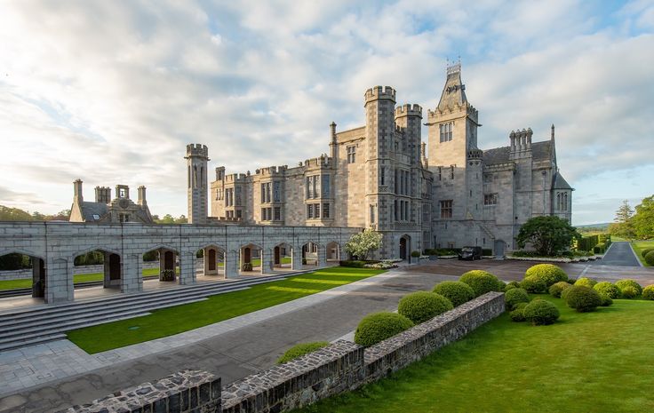 a large castle like building sitting on top of a lush green field